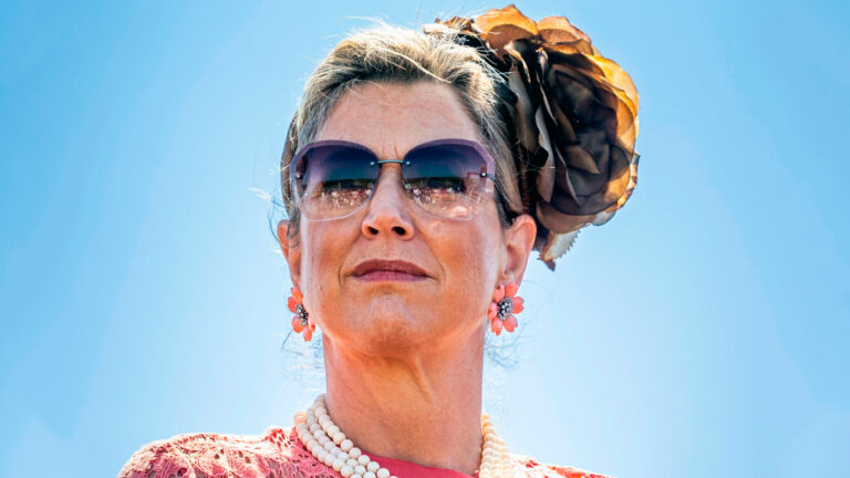 Queen Máxima’s Eye-Catching Outfit: Headdress with a Big Flower, Lace Dress, and Pearl Necklace Queen Máxima Visits Hogeland