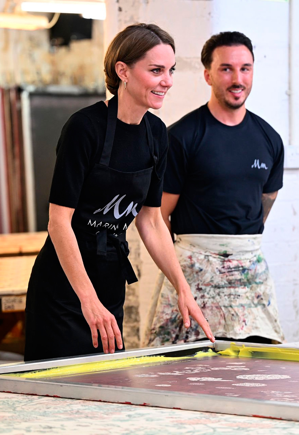 Kate helps lift screen printing frame during a visit to Marina Mill.