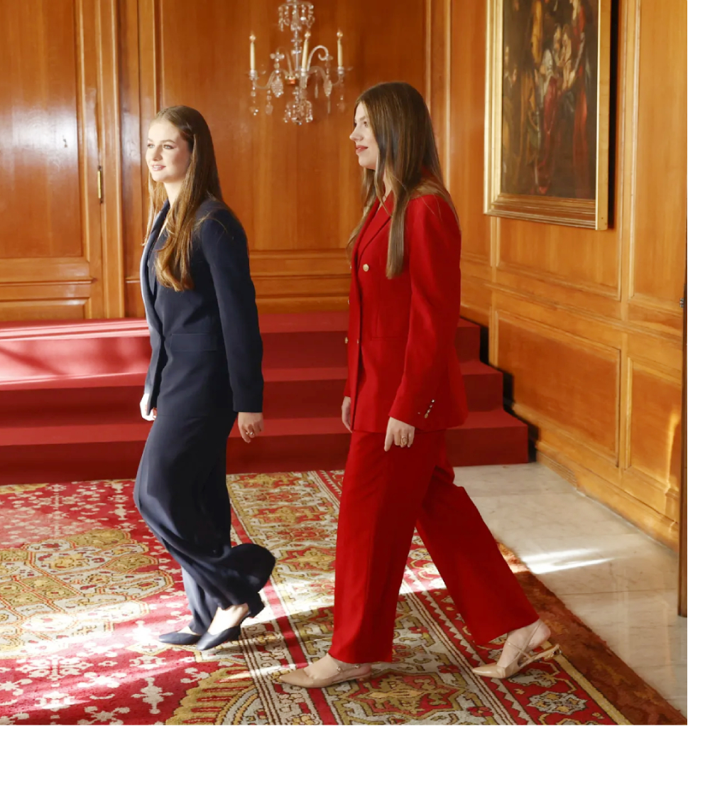Leonor wears a blue Hugo Boss suit and Sofia wears a red Tommy Hilfiger suit.