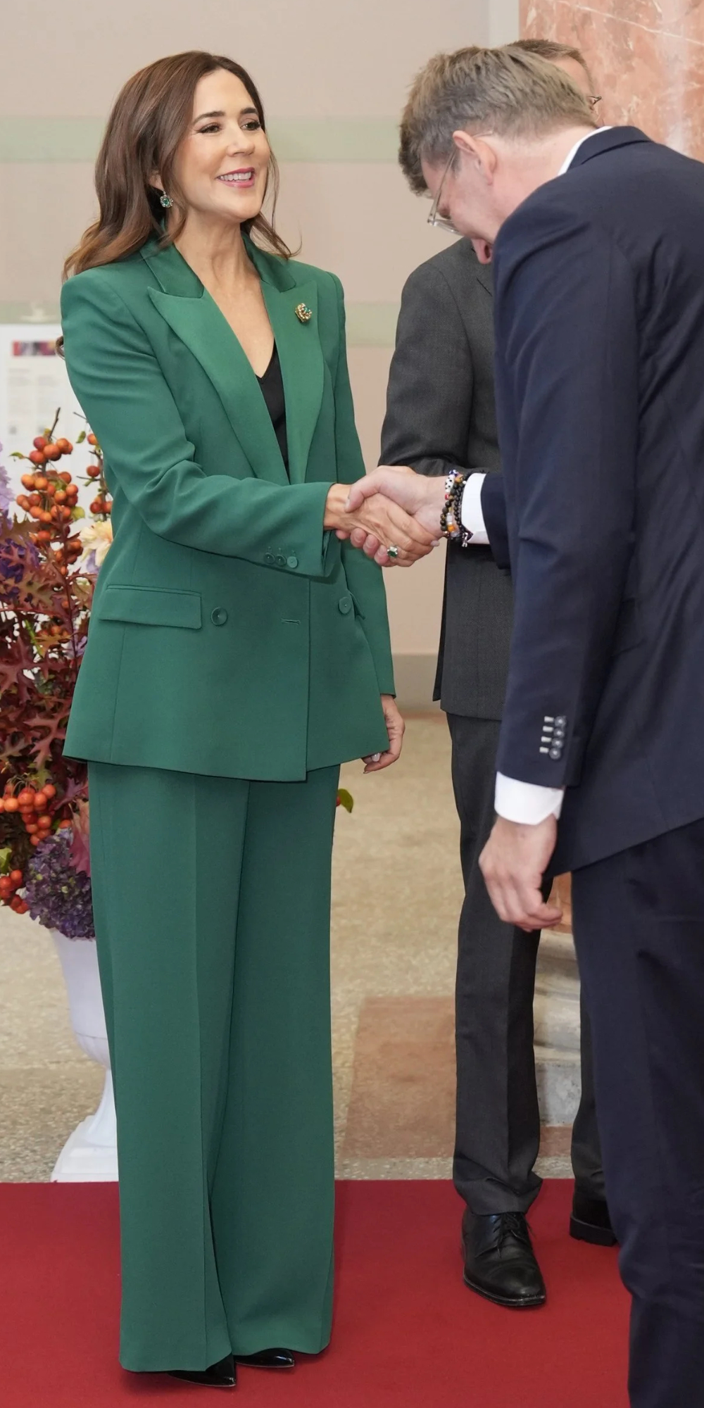 Queen Mary wears a green dress tailored by Alberta Ferretti.