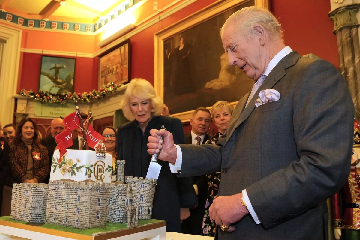 King Charles III and Queen Camilla cut a cake in the shape of the Cyfarthfa  castle.